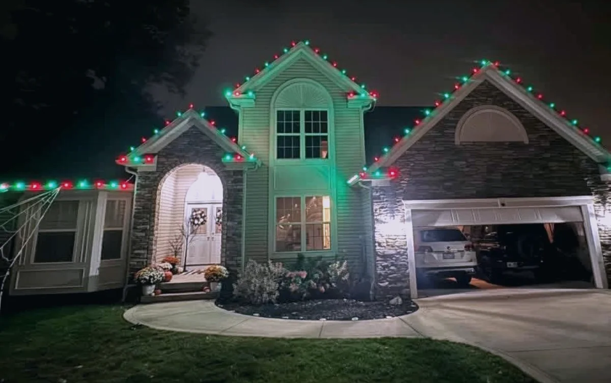 Red and green roofline on a multi-gable home with an arched entry